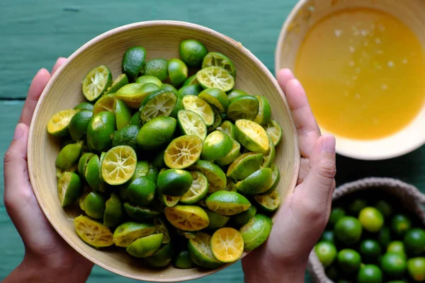 Top view people hand hold kumquat peel in green — Stock Photo, Image