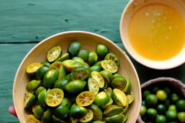 Top view people hand hold kumquat peel in green — Stock Photo, Image