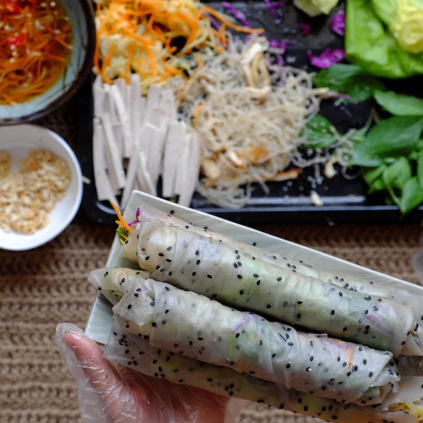 Top weergave mensen hand maken Vegan rijstpapier rollen — Stockfoto