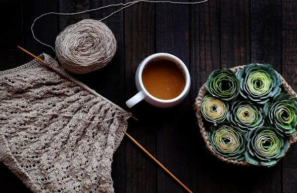 Ovanifrån kaffekopp, korg med grön ros, garn för stickning på blac — Stockfoto