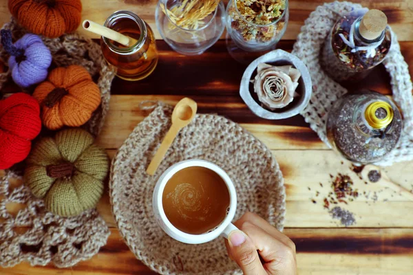 Mulher mão segurar xícara de café no fundo do outono com decoração seaso — Fotografia de Stock