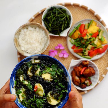 Üst düzey Vietnam mutfağı, öğle veya akşam yemeği için günlük aile yemeği, yosun çorbası, tofu, domates, ananas, bamya, soslu kurutulmuş ekmek pişirme, haşlanmış su ıspanağı çorbası.