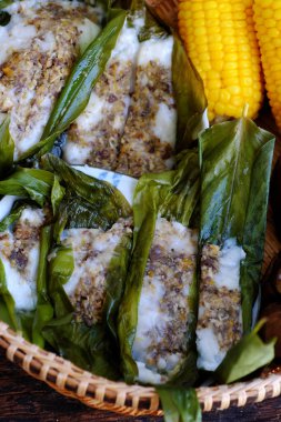 Öğle yemeği için nefis bir sepet Vietnam ev yapımı yemek, haşlanmış sarı mısır, buharda muz ve yapraklara sarılmış vejetaryen pirinç keki, içi pirinç unuyla doldurulmuş basit kek.