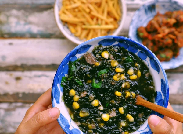 女子手握海藻 配上玉米汤碗 以素食为主食 简单的越南素食有利于健康 营养和美味 图库图片