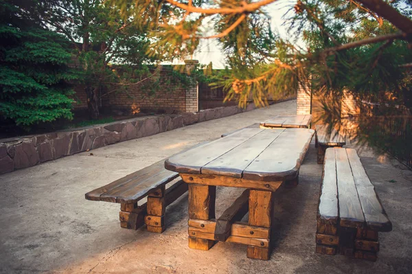 Prachtige houten picknicktafel en bankjes in een park bij zonsopgang gouden uur. Een prachtige plek voor een picknick onder de pijnbomen op zoek naar vredige serene meditatieve warme ontspannen rustgevende — Stockfoto