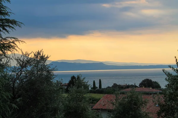 Garda Gölü'nde bulutlu bir günde gün doğumu