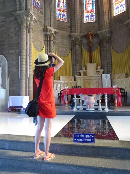 Tapınakta bir resim. Kırmızı elbiseli genç bir kız tapınakta fotoğraf çeker. Tanrı ile iletişim.