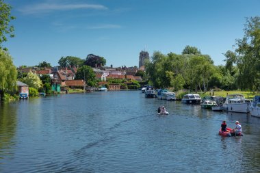 Beccles, Suffolk, İngiltere, İngiltere - 22 Haziran 2019: Broads Milli Parkı'ndaki Beccles'deki Waveney Nehri boyunca seyahat eden küçük teknelerdeki insanlar.