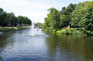 Zwolle, Netherlands - July 30, 2020: city park with lake in the center of Zwolle, with people relaxing in the background clipart