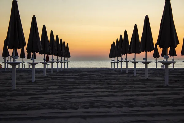 Het strand gestreeld door het zachte licht van de dageraad Stockfoto