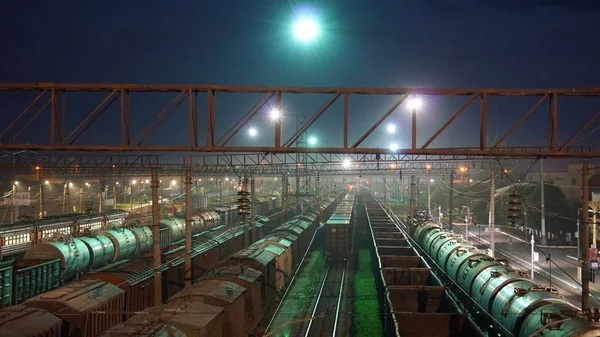 Gece ışıkları ışığında trenler ile gece tren rayları .