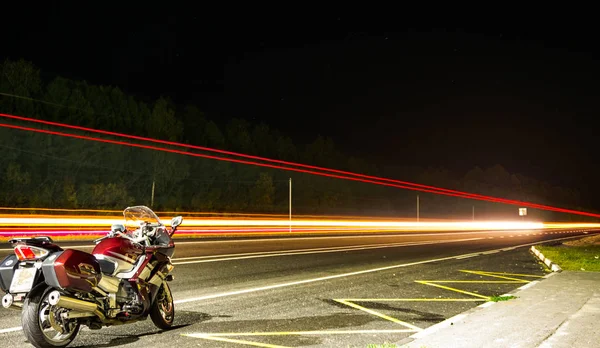 Motocicleta Fica Uma Pista Noturna Fundo Trilhas Luz — Fotografia de Stock