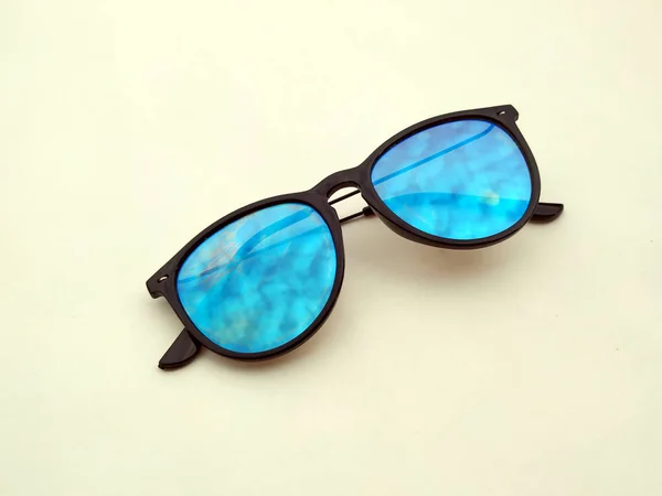 Children sunglasses, sun shades or spectacles isolated on light yellow  background. Color child glasses protection from sun and UV rays. Concept of sun protection and vacation.