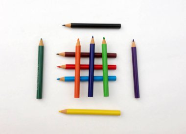 Beyaz arkaplanda birçok farklı renkli kalem var..