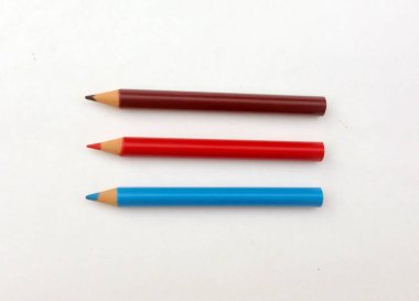 Beyaz arkaplanda birçok farklı renkli kalem var..