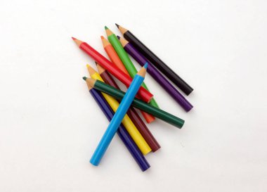 Beyaz arkaplanda birçok farklı renkli kalem var..