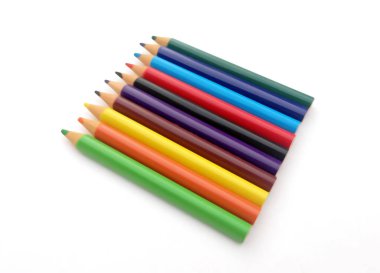 Beyaz arkaplanda birçok farklı renkli kalem var..