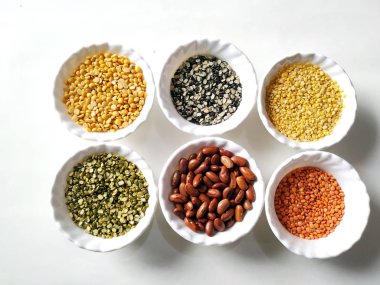 Beyaz arka plan üzerinde Beyaz kaselerde pişmemiş bakliyat, tahıl ve tohumlar. seçici odaklama