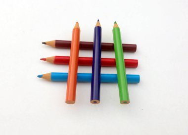 Beyaz arkaplanda birçok farklı renkli kalem var..