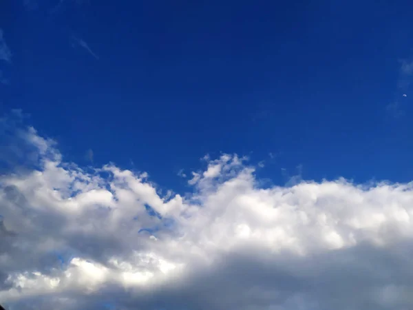 mavi gökyüzünde uçan yağmurlu bulutlar