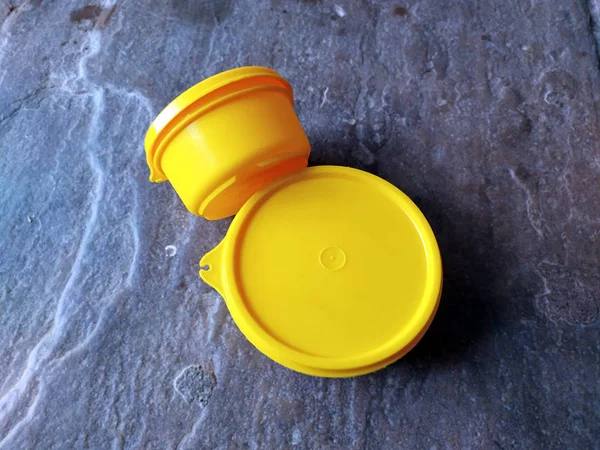 yellow plastic container box on stone background
