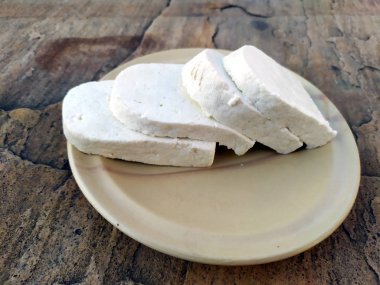 peynir dilimi taş arka plan üzerinde bir tabak koymak