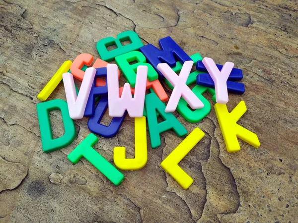 Многоцветные Пластиковые Буквы Алфавита Изолированы Каменном Фоне — стоковое фото