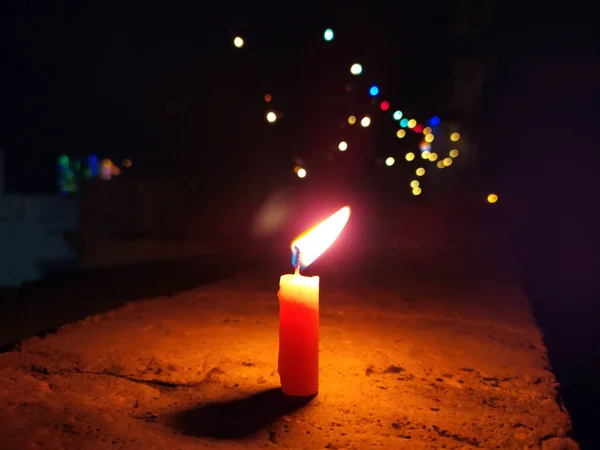 Een Kaars Vlam Geeft Licht Donkere Nacht Met Knipperlichten Achter — Stockfoto