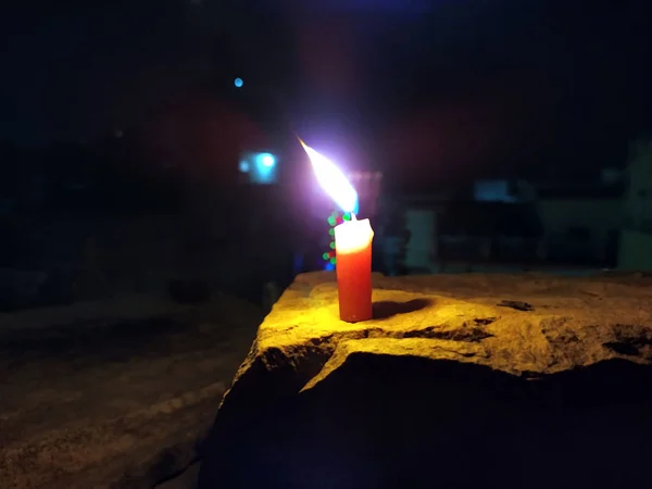 Een Kaars Vlam Geeft Licht Donkere Nacht Met Knipperlichten Achter — Stockfoto