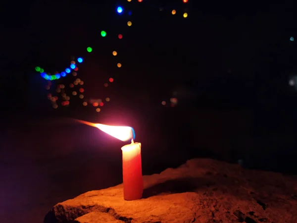 Eine Kerzenflamme Gibt Licht Dunkler Nacht Mit Blinkenden Lichtern Dahinter — Stockfoto