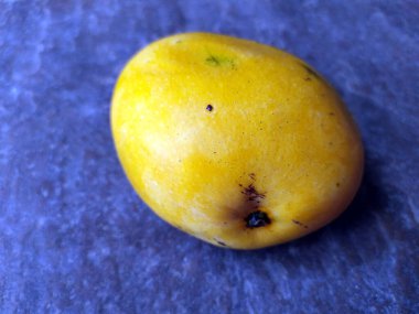 Taş zeminde izole edilmiş taze sarı mango.