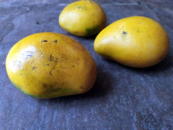 石の背景に閉じ込められた新鮮な甘い黄色のマンゴー — ストック写真