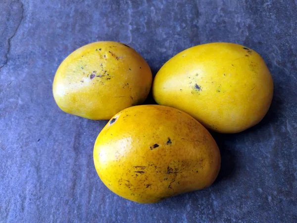 石の背景に閉じ込められた新鮮な甘い黄色のマンゴー — ストック写真