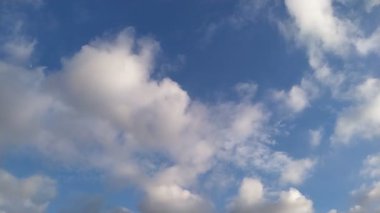 Mavi gökyüzünde uçan beyaz yağmurlu bulut