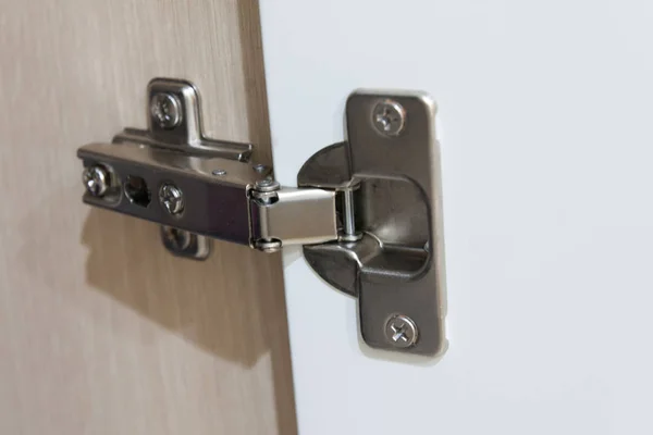 Stainless door hinges on cabinet door for interior design. Horizontal shot.