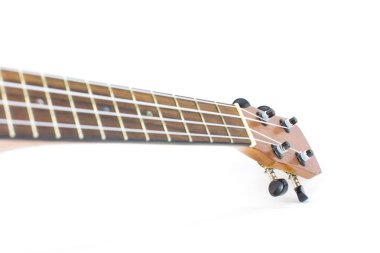 Koyu kahverengi ukulele Hawaii gitarının yakın plan başı seçilmiş odak noktası ve beyaz arkaplanda izole edilmiş kopyalama alanı