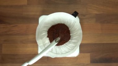 Kahveyi açmak için kağıt filtredeki kahve çekirdeklerine sıcak su dökmek. Dökme bir yöntemdir, kavrulmuş kahvenin üzerine su dökmeyi içerir..