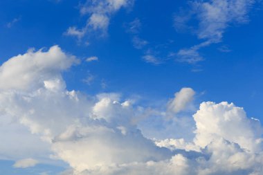 Beyaz bulutlar mavi gökyüzüne karşı güneşli bir yaz gününde.