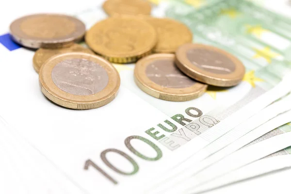 Yakın çekim Euro banknot ve madeni para yığını. 100 Euro banknot. Avrupa para para banknotları beyaz fon izole. Perspektif görünümü closeup. Maaş, tasarruf, Avrupa Birliği ekonomik kriz kavramı.