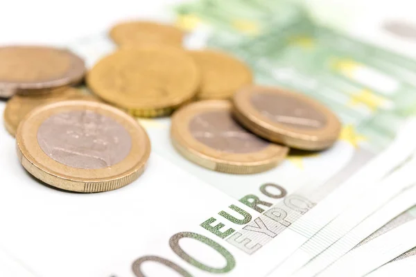 Yakın çekim Euro banknot ve madeni para yığını. 100 Euro banknot. Avrupa para para banknotları beyaz fon izole. Perspektif görünümü closeup. Maaş, tasarruf, Avrupa Birliği ekonomik kriz kavramı.