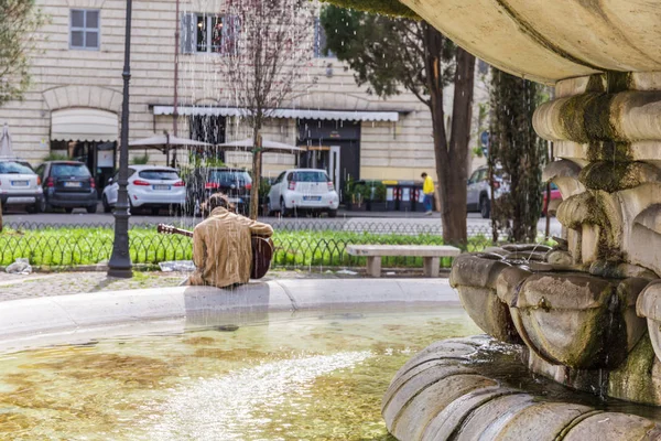 Prati bölgesinde Caryatids Çeşmesi'nde gitar çalan sanatçı, Roma, İtalya.