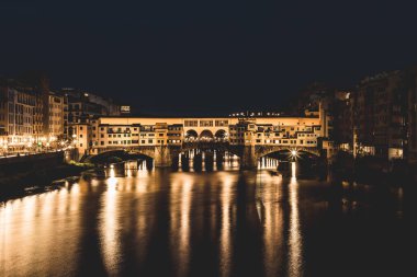 Ponte Vecchio ve Binalar gece nehre Arno yansıtan tarafından kapatın. Floransa, İtalya.