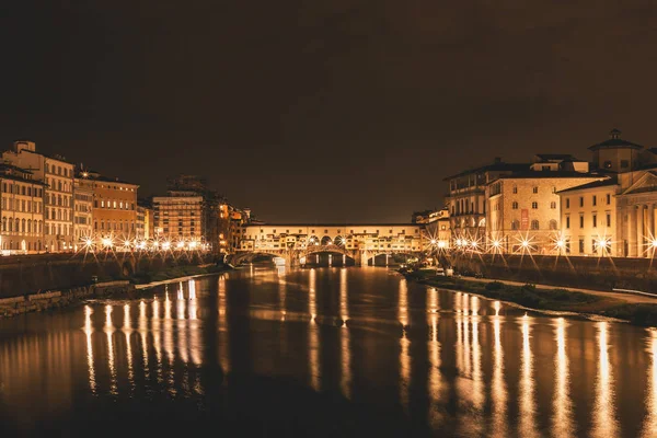 Ponte Vecchio ve Binalar gece nehre Arno yansıtan tarafından kapatın. Floransa, İtalya.