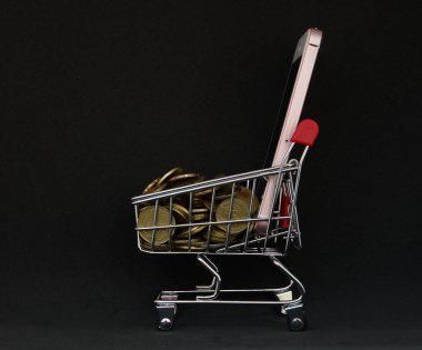 Online alışveriş konsepti. Sepeti ve sikke ve siyah arka plan ile Akıllı telefon                                       