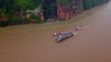 Leshan nehrine yağmur yağıyor. Dünyanın en büyük Buda 'sının önünde turistli tekneler, kızıl dağlara oyulmuş. Chengdu, Çin