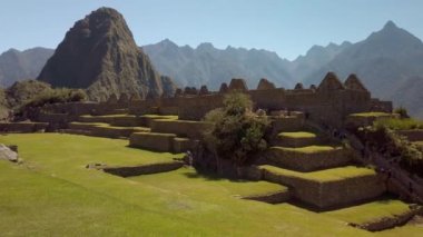 Arka planda Huayna Picchu tepesi olan Machu Picchu binaları, evler ve inka mimarisi