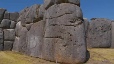 Antik İnka kalesinin savunma duvarına mükemmel uyacak şekilde oyulmuş ve yuvarlanmış dev bir taş blok. Sacsayhuaman Arkeoloji Parkı, Cusco şehri. Peru