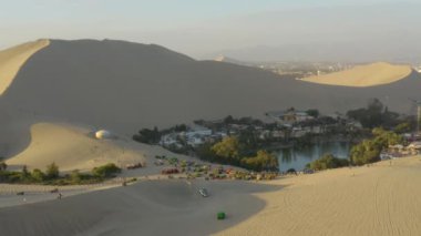 Perulu insanlar kum tepeciklerinde at arabaları kullanıyorlar. Huacachina Vahası, Peru 'da halk Peru Bağımsızlık Günü' nü kutluyor.