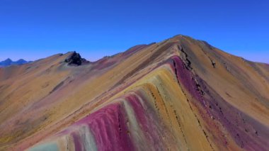 Vinicunca Vadisi 'ndeki Gökkuşağı Dağı Tepesi' nin havadan manzarası. Yoğun kırmızı, sarı, turuncu, yeşil ve mavi renkleri olan bir dağ. Gözetleme noktasındaki ziyaretçiler tepede. Onlara bakın..