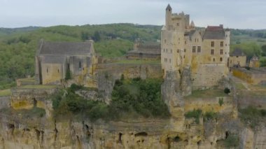 Beynac Havacılık Kalesi Dordogne Nehri üzerinde bir uçurum inşa ediyor. Sarı, beyaz ve ocre renkleri kayalara hükmediyor. Aquitaine, Güney Fransa.